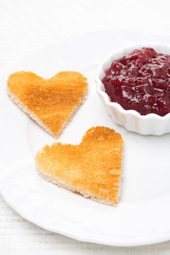 toasted bread in the shape of heart with berry jam, close-up
