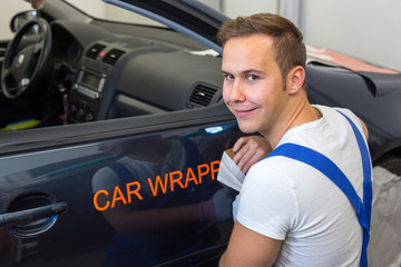 Car wrapping specialist puts logo on vehicle door