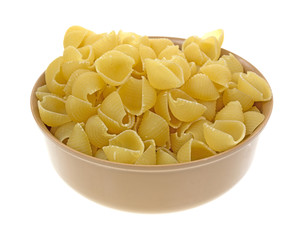 Small pasta shells in a tan bowl
