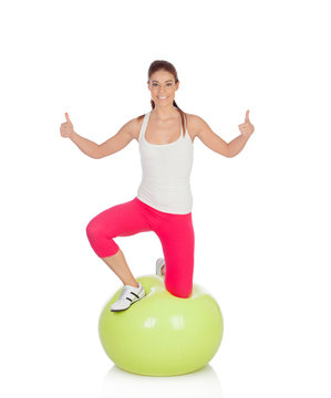 Attractive woman doing pilates with a big green ball