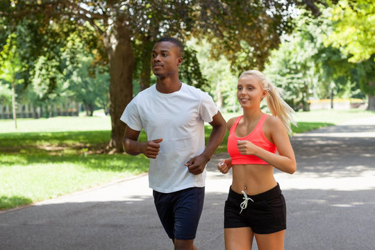 zwei sportliche junge jogger laufend im park im sommer