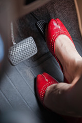 A woman's foot depressing the brake pedal of a car