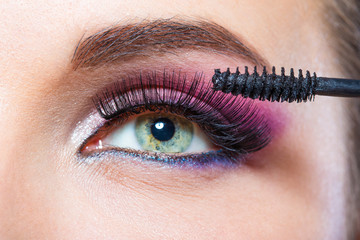 Obraz premium Close up of female eye with bright make-up and brush