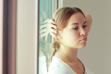 beautiful woman stands in front of the window