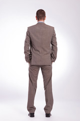 back of a young business man with both hands in pockets