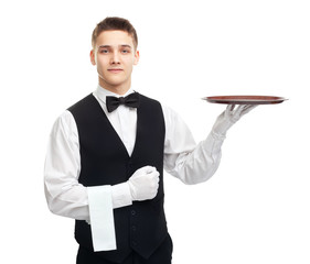 Young smiling waiter with empty tray