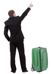 Back view of pointing business man traveling with suitcas .