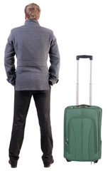 Back view of young man traveling with suitcas.