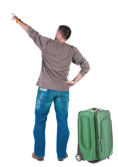 Back view of  pointing young men traveling with suitcas .