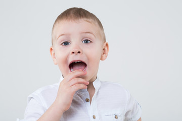 Boy in a white shirt with an open mouth in the studio