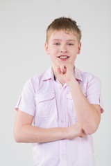 The boy in a pink shirt propping up hand to head