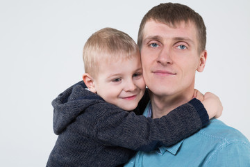 Little boy hugging his father, closeup photo in studio