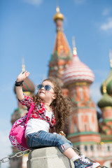 The little girl in stylish dress near the cathedral