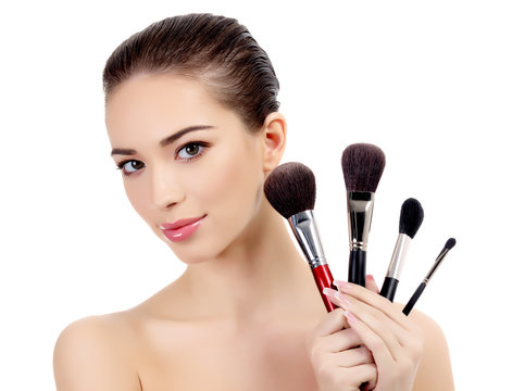 Pretty woman with cosmetic brushes, white background
