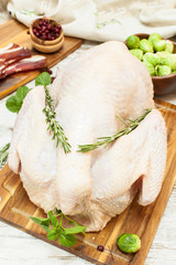 Whole raw  turkey on wooden cutting board with ingredients