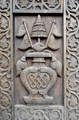Carved wooden details on a temple door with the Nepalese flag