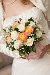 Bride with weeding roses bouquet in green