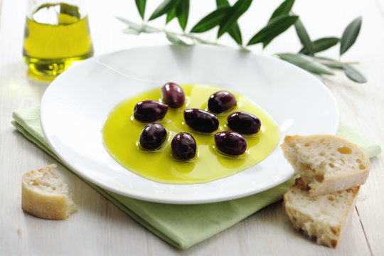 Olive Oil and Black Olives on a Plate with Bread