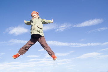little girl jumping high in the air. Autumn in mountain.