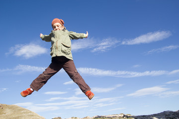 little girl jumping high in the air. Autumn in mountain.
