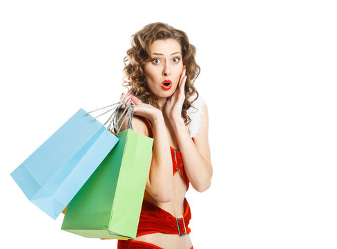 Surprised christmas girl isolated holding colorful packages