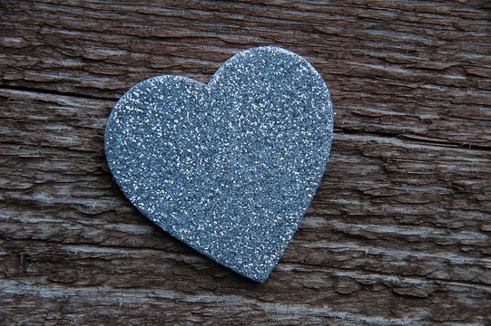Silberfarbenes Herz auf altem Holz