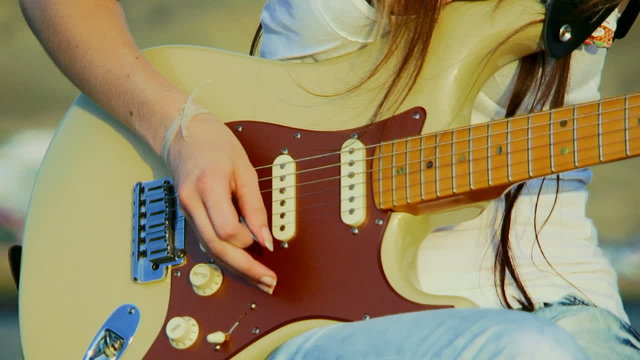 Girl playing guitar. Close-up