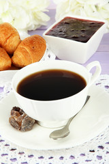Tasty croissants and cup of coffee on table close-up