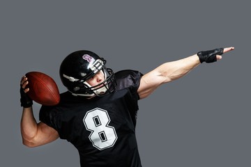 American football player with ball wearing helmet and jersey