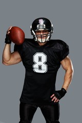 American football player with ball wearing helmet and jersey