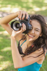 High angle view of cheerful young woman taking a picture