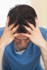 Fototapeta premium Casual worried man sitting on couch