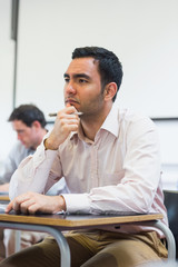 Mature students taking notes in classroom