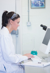 Young female researcher using computer in lab