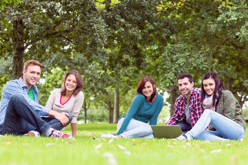 Fototapeta premium Young college students using laptop in the park