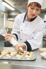 Pretty focused head chef preparing dessert