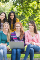 Fototapeta na wymiar Young college girls with laptop in park