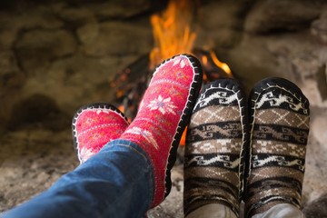Close-up of romantic legs in socks in front of fireplace
