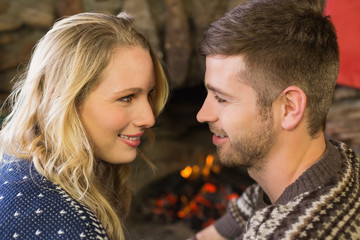 Fototapeta premium Romantic couple smiling in front of fireplace