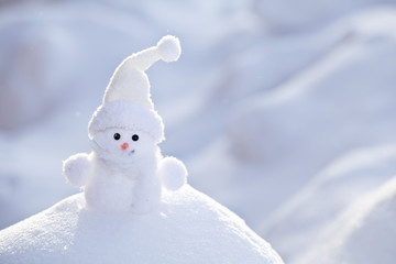 Little funny white snowman in the snowbank.