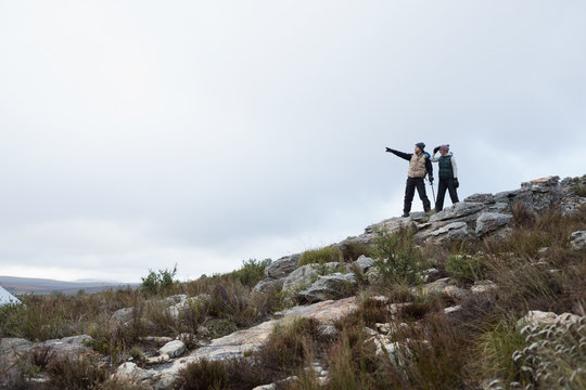 Couple standing on rocky landscape against clear sky