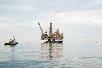 Fototapeta na wymiar Oil rig being tugged in the sea