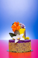 Colorful cake decorated with candy flowers and lace