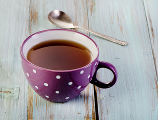 Cup of black tea and spoon
