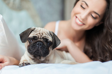 Attractive young girl with dog while laying on bed
