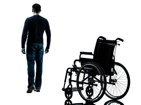 man walking away from wheelchair silhouette