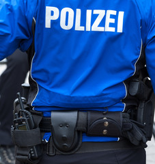 Polizist mit Einsatzgurt Dienstwaffe und Funkgerät