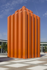 Orange sculpture of a skyscraper.