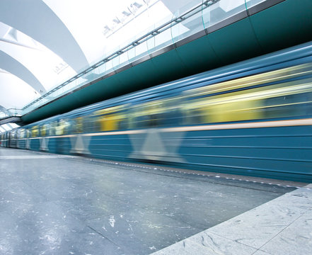 spacious public metro marble station with fast blurred train