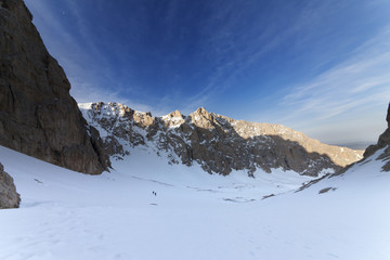 Two hikers on snowy mountains in morning